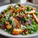 Slices of ripe pear and crumbled blue cheese in a Frisée Pear Blue Cheese Bowl, ready to serve at a sunny lunch.