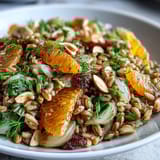 A hearty serving of Farro Salad Bowl featuring nutty grains, crisp fennel, and bright citrus, ready to eat from a wooden bowl.