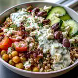Hearty Mediterranean Farro Bowl with spinach, chickpeas, tomatoes, cucumber, and Kalamata olives. 