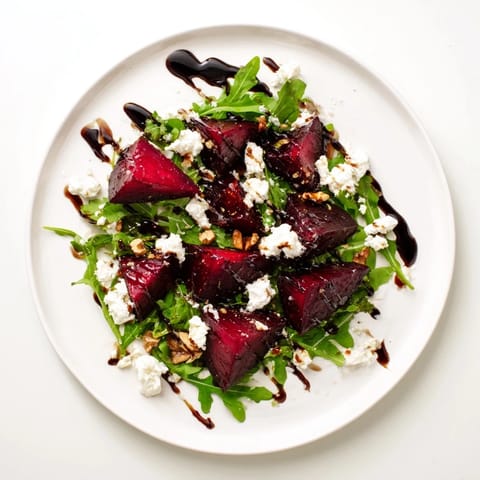 Hearty and colorful, this Roasted Beet Goat Cheese Salad features glossy roasted beets, tangy goat cheese crumbles, and toasted walnuts tossed with peppery arugula in a bright vinaigrette.