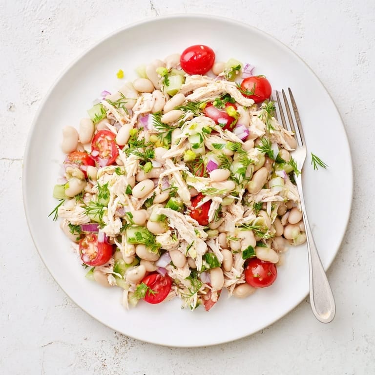 Close-up of Lemony White Bean Chicken Salad highlighting shredded chicken, white beans, and fresh parsley, glistening with a tangy lemon herb dressing.