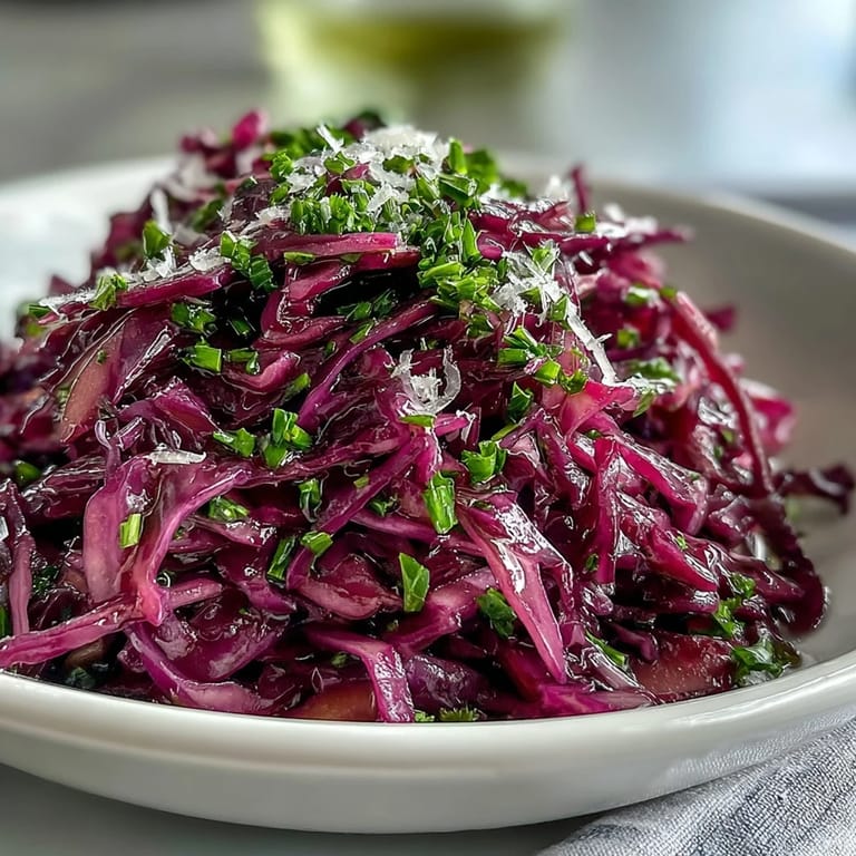 Freshly tossed Red Cabbage Coleslaw With Apple and Parmesan features crunchy apple slices, shaved cheese, and spring onions in a rustic serving dish.