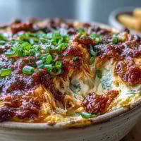 Golden, bubbly Buffalo Chicken Dip fresh from the oven, topped with melted cheddar and fresh green onions for a spicy game day snack.