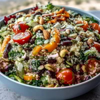 Vibrant Rainbow Salad Bowl filled with quinoa, chickpeas, and crunchy cashews, ready for a nutritious lunch.